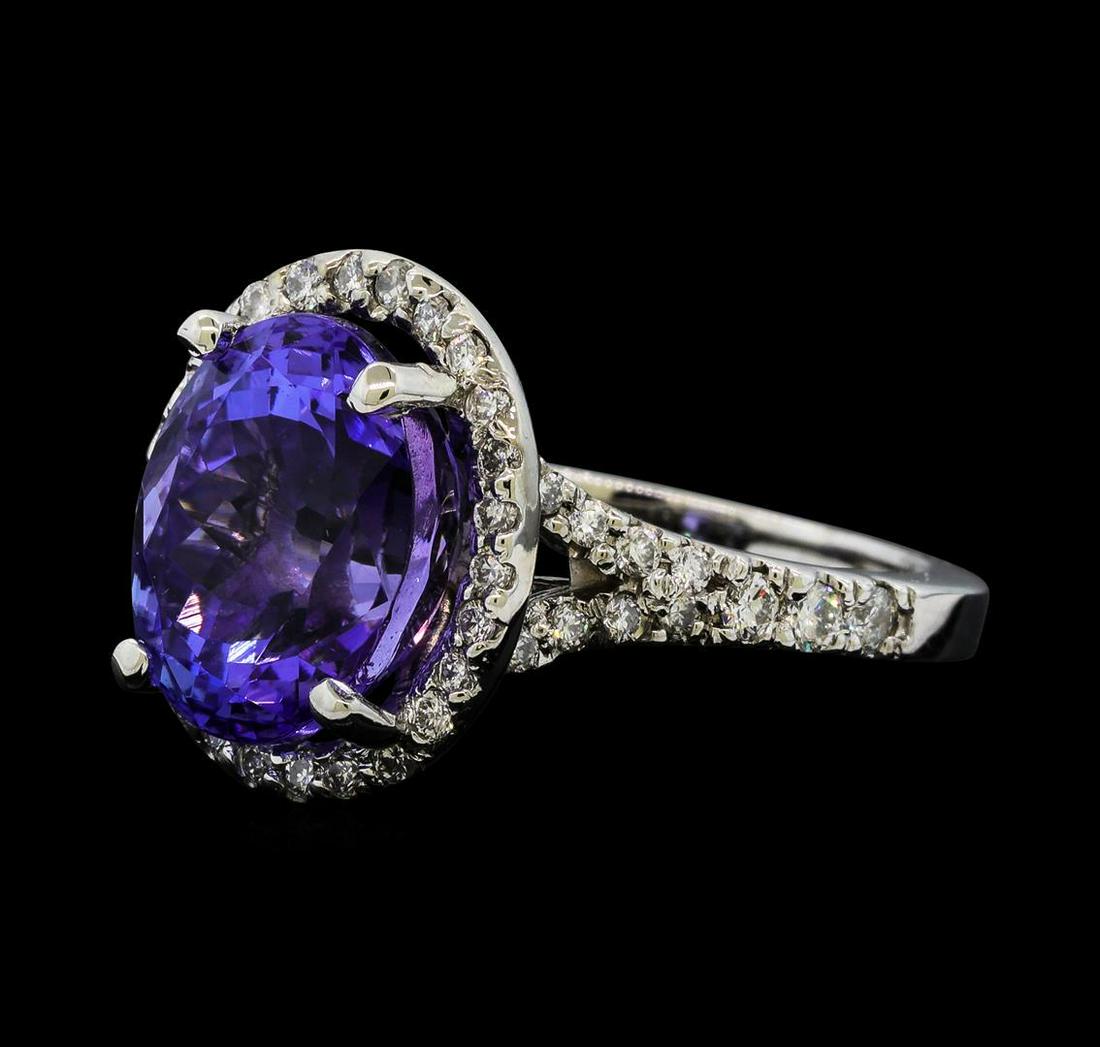 5.65 ctw Tanzanite and Diamond Ring - 14KT White Gold: One electronically tested 14KT white gold lady's cast fashion ring with a split shank basket halo with a bright polish finish. The featured lady's ring has a shank measuring 2.08 millimeters wide. Ide