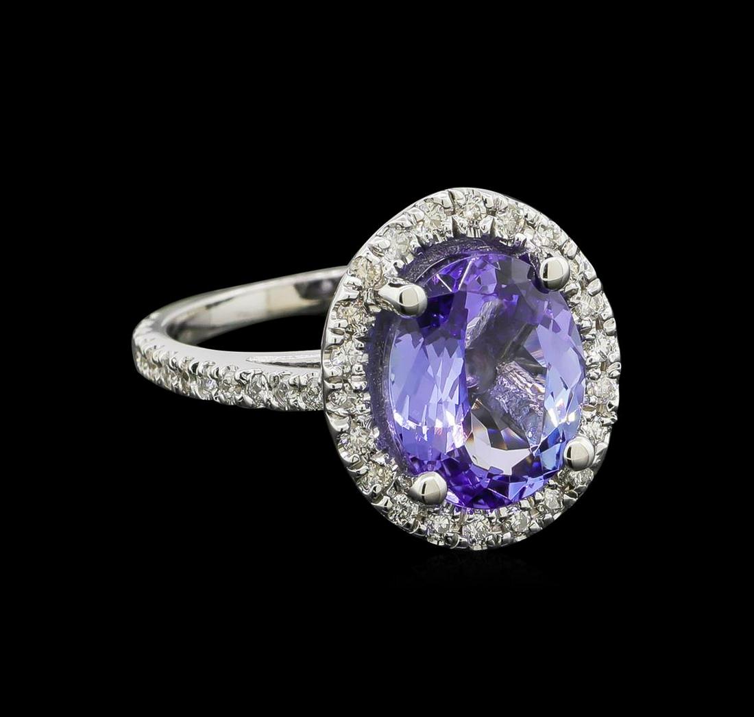 4.6 ctw Tanzanite and Diamond Ring - 14KT White Gold: One electronically tested 14KT white gold lady's cast fashion ring with a halo with a bright polish finish. The featured lady's ring has a shank measuring 1.80 millimeters wide. Identified with markin