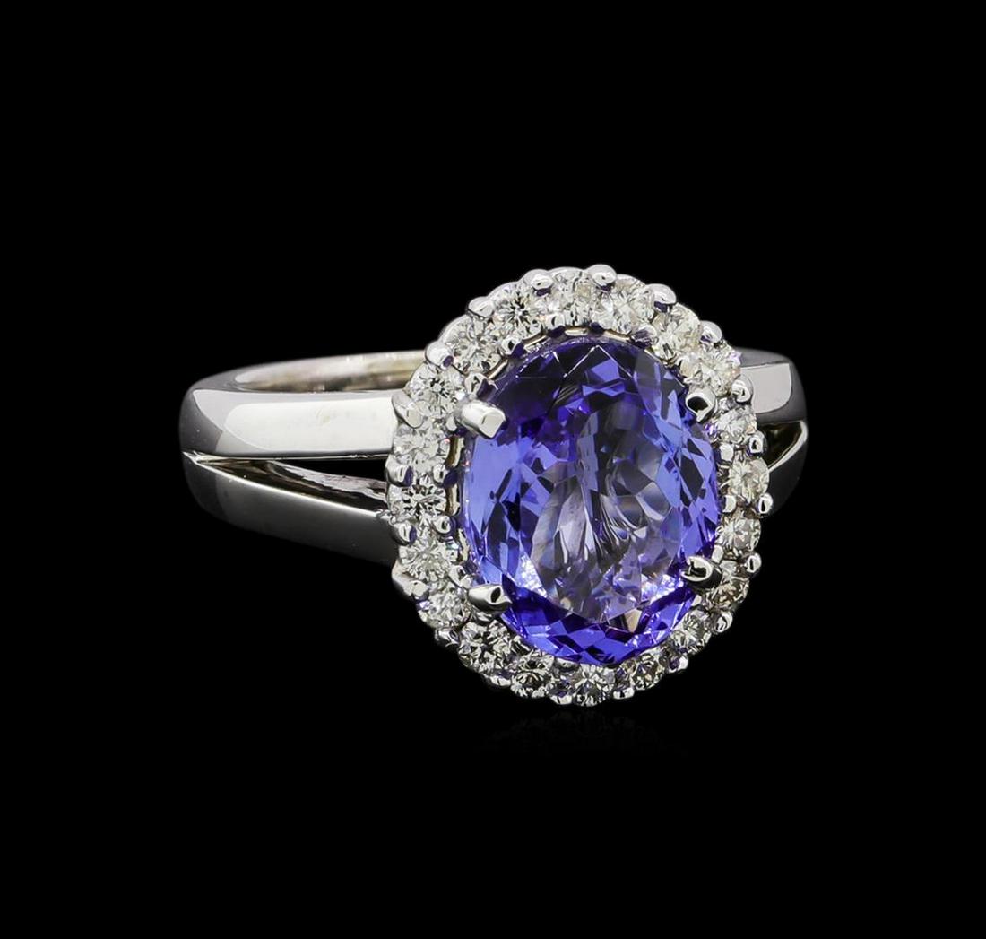 3.54 ctw Tanzanite and Diamond Ring - 14KT White Gold: One electronically tested 14KT white gold lady's cast fashion ring with a split shank basket halo with a bright polish finish. The featured lady's ring has a shank measuring 3.0 millimeters in width. 