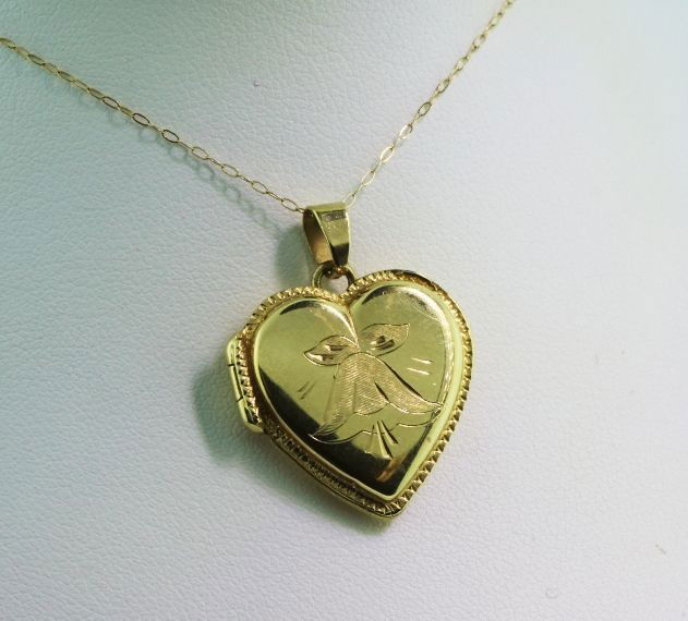 14K Gold Locket 4.2 gm GD35: 14K Gold Locket 4.2 gm GD35. As-Is Condition! BY531AS. One 14K gold heart locket with a 14 14K gold chain. Bell shaped flower is engraved on front of heart. This locket has markings of "ITALY" and the