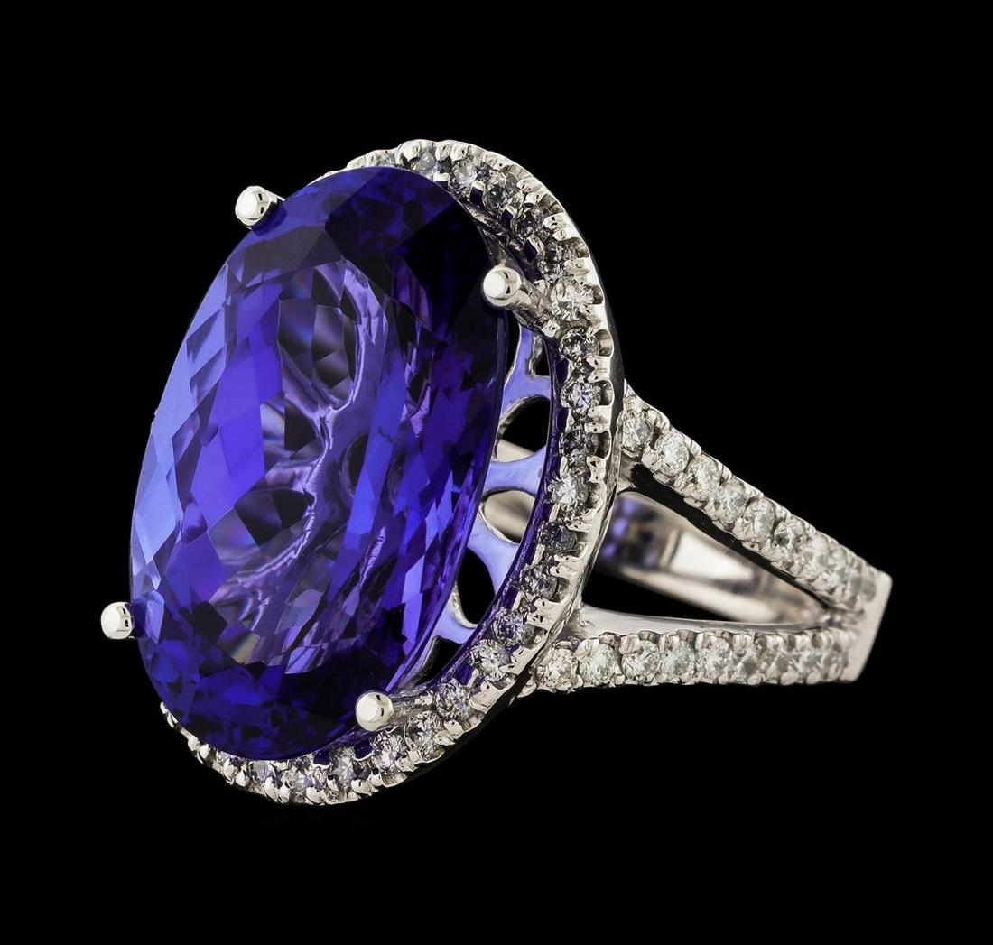 12.38 ctw Tanzanite and Diamond Ring - 14KT White Gold: One electronically tested 14KT white gold lady's cast fashion ring with a split cathedral shank with a halo with a bright polish finish. The featured lady's ring has a shank measuring 2.77 millimeters
