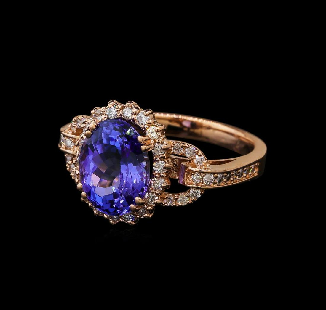 3.59 ctw Tanzanite and Diamond Ring - 14KT Rose Gold: One electronically tested 14KT rose gold lady's cast fashion ring with a basket halo with a bright polish finish. The featured lady's ring has a shank measuring 2.59 millimeters wide. Identified with 