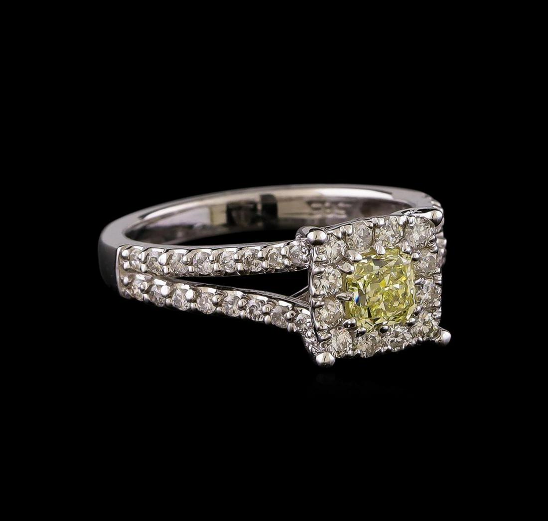 1.09 ctw Fancy Yellow Diamond Ring - 14KT White Gold: One electronically tested 14KT white gold lady's cast wedding ring with a split shank halo with a bright polish finish. The featured lady's ring has a shank measuring 2.47 millimeters wide. Identified