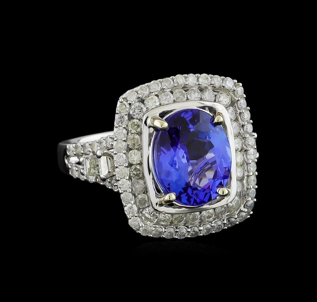3.86 ctw Tanzanite and Diamond Ring - 14KT White Gold: One electronically tested 14KT white gold ladies cast tanzanite and diamond ring with a bright polish finish. The featured tanzanite is set within tiered diamond bezels supported by diamond set split 