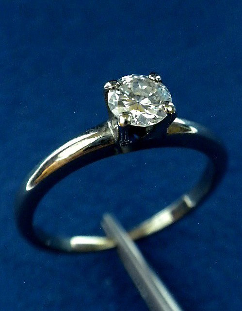 18KT White Gold Diamond Solitaire Ring A2576: "18KT White Gold Diamond Solitaire Ring A2576. Good Condition! PM19KX. One electronically tested 18KT white gold ladies cast diamond solitaire ring with a bright polish finish. Condition is good. Iden