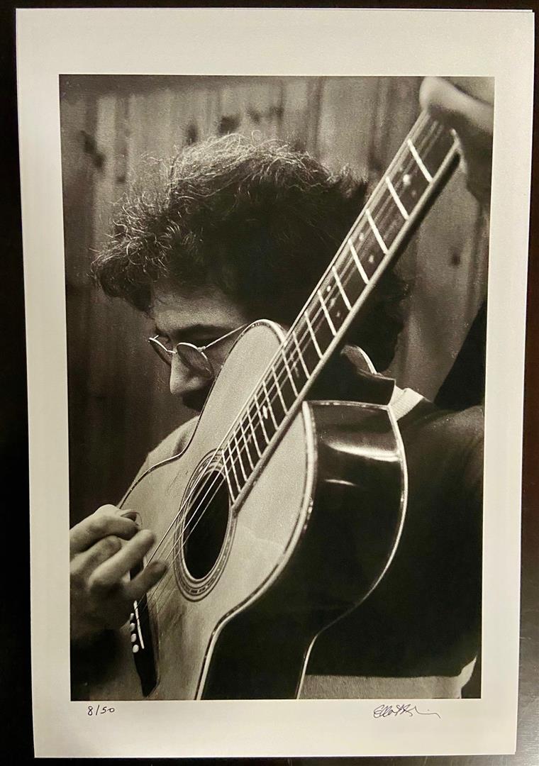 Jerry Garcia w/ Big Guitar by Elliot Blinder: A s/n 15x10" image on 18x12" paper of Jerry Garcia tuning his guitar backstage at The Boston Tea Party in 1969.By Rolling Stone Photographer Elliot Blinder.