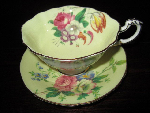 Paragon Fine Bone China- unique Cup & Saucer Set BD77: "Paragon Fine Bone China- unique Cup & Saucer Set BD77. Excellent Vintage Condition! RT13PT. This pastel yellow set has beautiful handpianted flowers inside the cu and on the saucer. There is a gold p