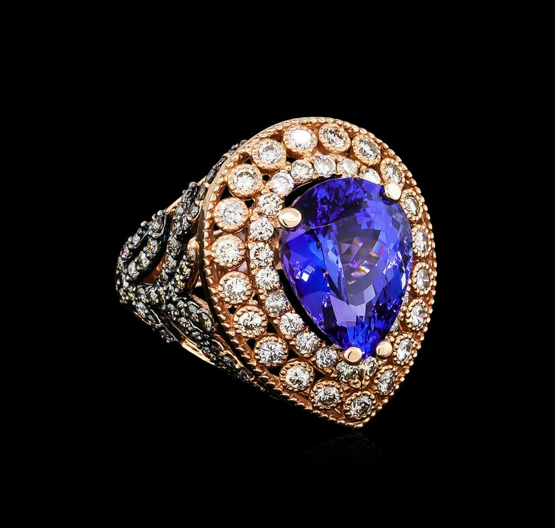 7.31 ctw Tanzanite and Diamond Ring - 14KT Rose Gold: One electronically tested 14KT rose gold ladies cast tanzanite and diamond ring. The featured tanzanite is set within tiered diamond bezels supported by diamond set floral motif shoulders, completed b
