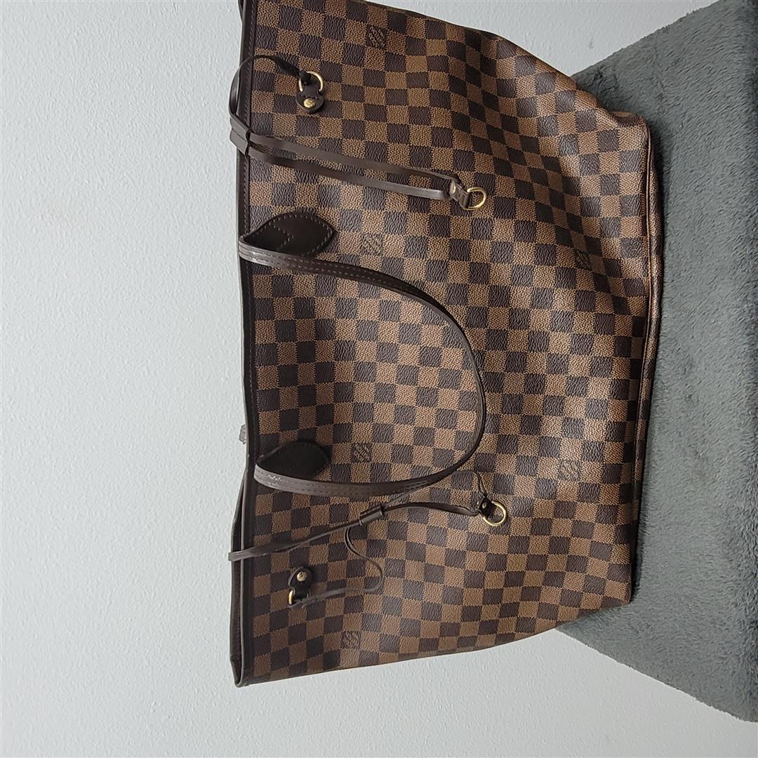 Louis Vuitton Neverfull GM Damier Ebere Tote Bag: One Louis Vuitton Neverfull GM Damier Ebere Tote Bag. The Neverfull GM features a monogram canvas body with a leather trim, flat shoulder straps, an open top, and an interior zip pocket.
