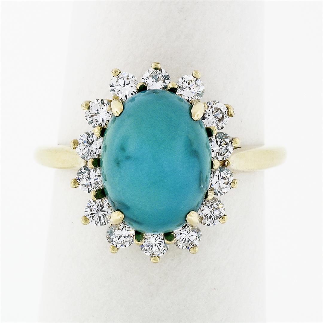 Vintage 18k Yellow Gold Oval Cabochon Turquoise Solitaire & Diamond Halo Ring: A solid 18k yellow gold ring, with 1 oval cabochon cut natural turquoise (11.1x8.5mm ), surrounded with a halo of 14 round brilliant cut natural diamonds (E/F - VVS2/VS1 ; 0.70ctw). The ring is size 6
