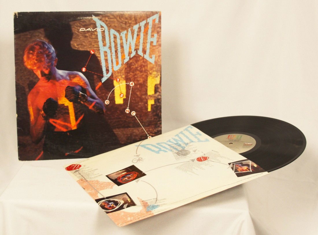 David Bowie "Lets Dance" Vinyl Record BD183: David Bowie Lets Dance" Vinyl Record BD183. As-Is Condition! CA6WD. David Bowie "Lets Dance" Vinyl Record. Circa 1983, by EMI America. Thank you for viewing this lot. We are always adding new inventor