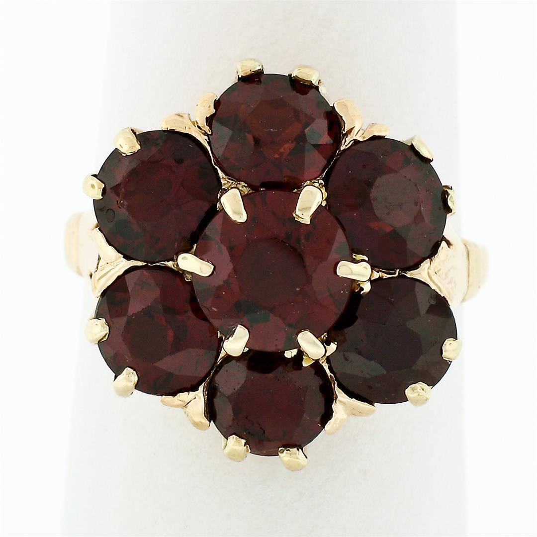 Vintage Retro 14k Gold 7.6 ctw Garnet Solitaire Halo Cluster Flower Cocktail Rin: A vintage solid 14k yellow gold cluster flower ring, with 7 old round cut natural garnets (6mm to 7mm; 7.6ctw). The ring is size 7.0, weighs a total of 6.42 grams, and measures 18mm wide.