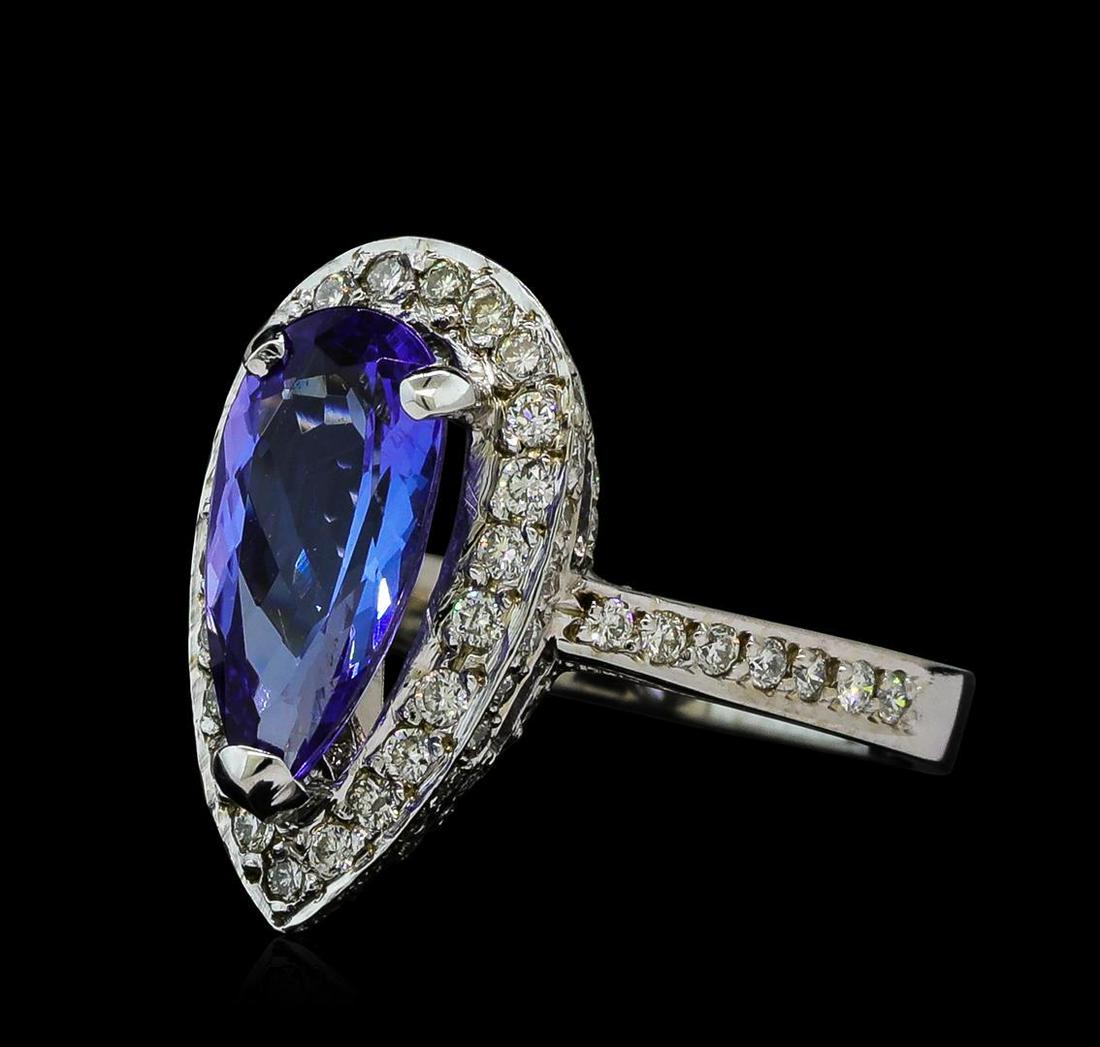 2.19 ctw Tanzanite and Diamond Ring - 14KT White Gold: One electronically tested 14KT white gold ladies cast tanzanite and diamond ring with a bright polish finish. The featured tanzanite is set within a diamond bezel supported by a diamond set lattice un