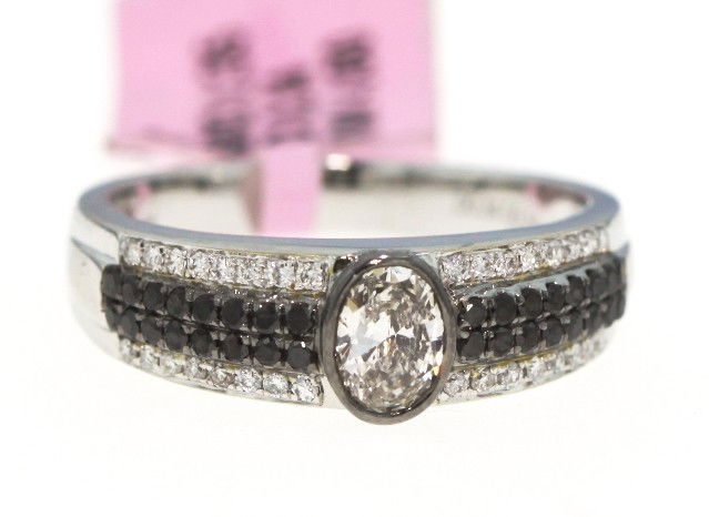 18KT White Gold .69ct Black and White Diamond Ring FJM7: 18KT White Gold .69ct Black and White Diamond Ring FJM762. Excellent Condition! RI2201SM. One 18KT white gold black and white diamond ring. The center white diamond is 0.34cts surrounding it are black