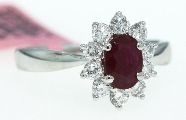 18KT White Gold 1ct Ruby and Diamond Ring FJM729: 18KT White Gold 1ct Ruby and Diamond Ring FJM729. Excellent Condition! KA8511DM. One 18KT white gold H. Emperor ruby and diamond ring. Features one oval cut ruby weighing 1.00ct surrounded by 10 round