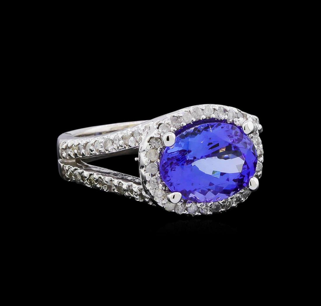 3.77 ctw Tanzanite and Diamond Ring - 14KT White Gold: One electronically tested 14KT white gold ladies cast tanzanite and diamond ring with a bright polish finish. The featured tanzanite is set within a diamond bezel supported by a diamond set under gall