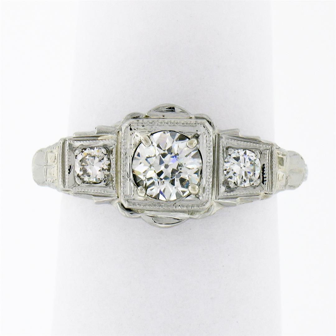 Antique Art Deco 18k Gold .70 ctw 3 Stone European Diamond Filigree Engraved Rin: An antique solid 18k white gold engraved band ring, with 3 old european cut natural diamonds (G/H- VS1/VS2; 0.70ctw). The ring is size 5.0, weighs a total of 2.57 grams, and measures 8.7mm wide.