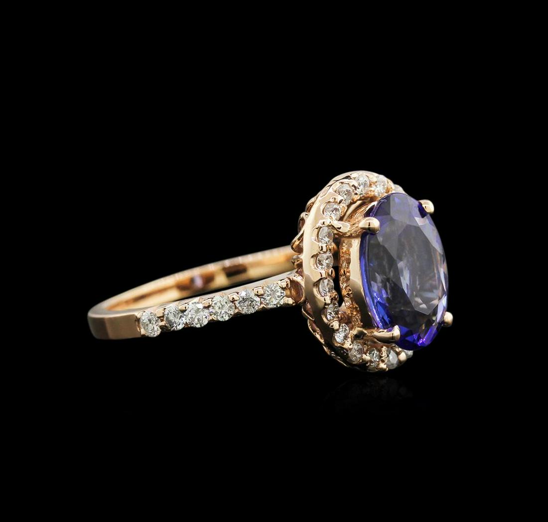 2.07 ctw Tanzanite and Diamond Ring - 14KT Rose Gold: One electronically tested 14KT rose gold lady's cast fashion ring with a basket setting with a bright polish finish. The featured lady's ring has a halo motif with a shank measuring 1.72 millimeters i