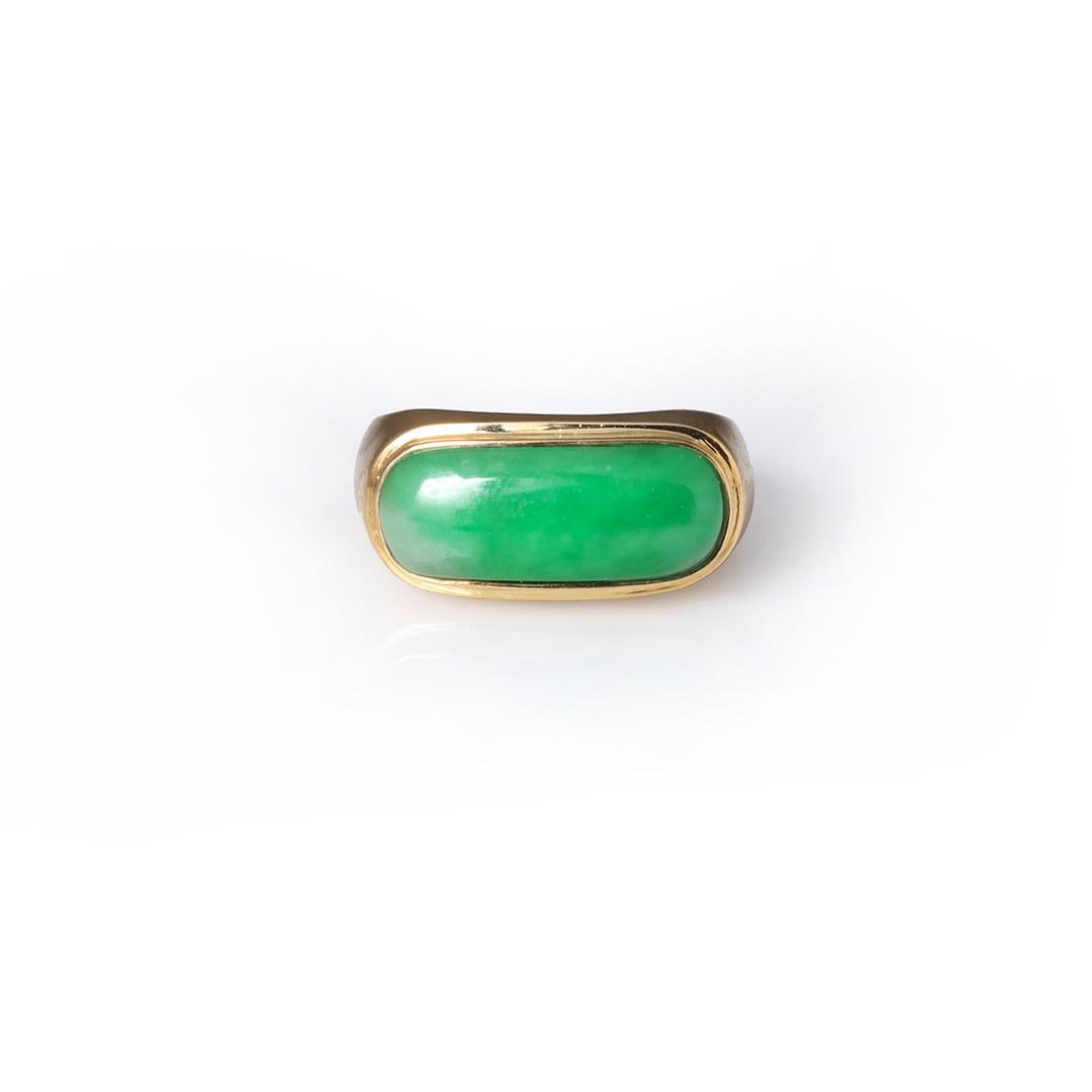 A Handmade 18K Yellow Gold & Jadeite Saddle Ring: A simple design set within a bezel; the apple green jadeite slightly raised and offering hues of various shades of green, stamped on the interior WT (for William Terrance Jewelers Hong Kong) with addi