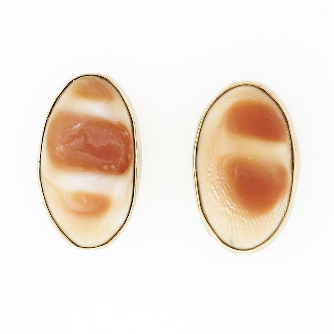 Vintage 14k Yellow Gold Bezel Set Carved Wavy Oval Shell Petite Stud Earrings: A vintage solid 14k yellow gold earrings, with carved oval shape natural shell (13.50x7.95mm). The earrings measure approximately 14.45x9mm and weigh a total of 3.11 grams.