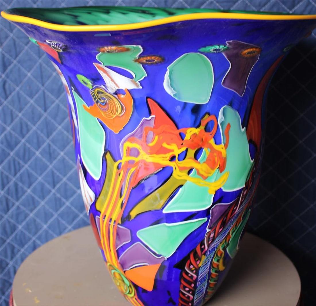 Blue Chard Vase #418 by Dutch Schulze: Glass sculptor, Dutch Schulze, incorporated a myriad of vibrantly-hued abstract designs into a deep-blue glass vase. The vase #418 measures 15x 14 x 13.s