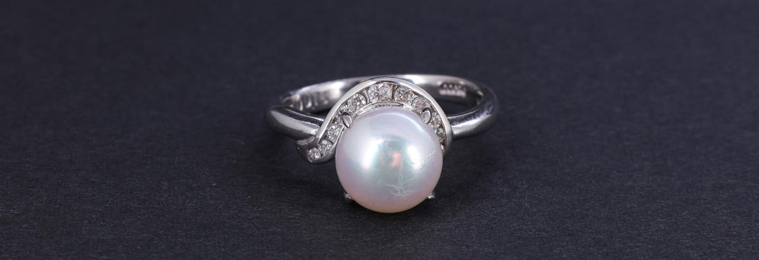 Platinum South Sea Pearl & Diamond Ring: A platinum ring set with South Sea round pearl measuring approximately 9mm surrounded by approximately .16 carats of diamond accents, the interior of the ring marked D0.16 Pt900; gross weight 5.1 g, s