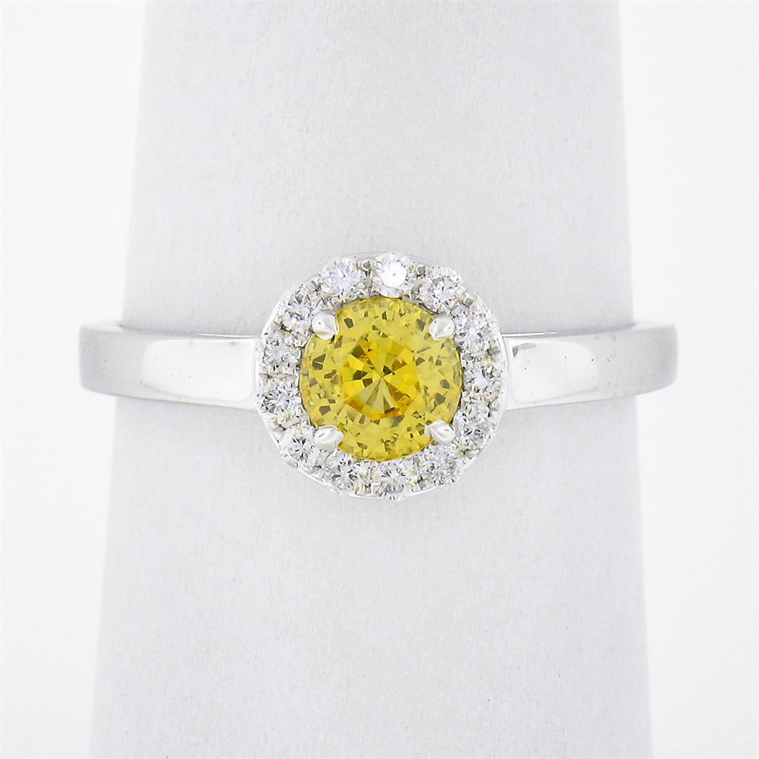 NEW 14K White Gold 0.96 ctw Ceylon Yellow Sapphire Solitaire w/ Diamond Halo Rin: A new solid 14k white gold solitaire ring, with 1 round brilliant cut natural yellow sapphire (0.76ct), and 13 round brilliant cut natural diamonds (G/H - VS1/VS2 ; 0.20ctw). The ring is size 7.0, wei