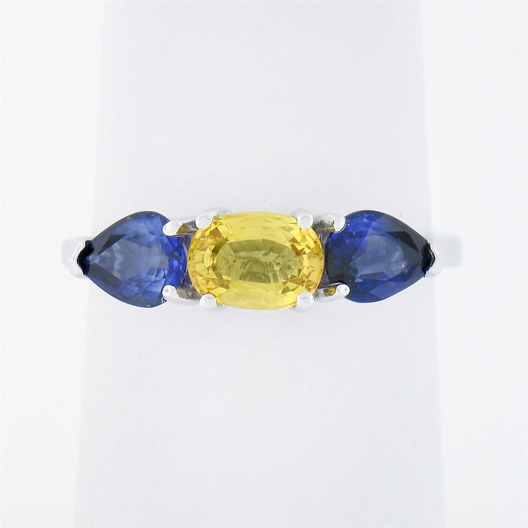 14k White Gold 2.25 ctw Oval Yellow & Pear Cut Blue Sapphire Three 3 Stone Ring: A solid 14k white gold 3 stones ring, featuring 1 oval brilliant cut natural yellow sapphire (1.00ct ), and 2 pear cut natural blue sapphires (1.25ctw). The ring is size 7.0, weighs a total of 2.87 gr