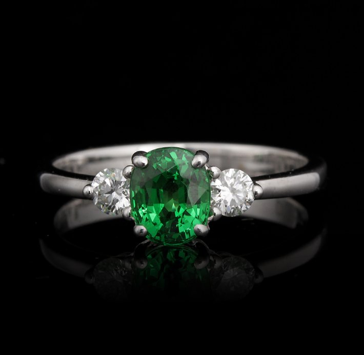 18KT White Gold 1.16ct Tsavorite and Diamond Ring FJM25: 18KT White Gold 1.16ct Tsavorite and Diamond Ring FJM2516. Excellent Condition! NS975GF. One ring featuring: 2.79gm of 18KT white gold, (1) tsavorite with a total weight of 1.16cts and (2) round cut d