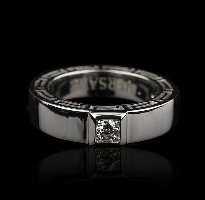 Ladies Versace 18KT White Gold Diamond Ring GB658: Ladies Versace 18KT White Gold Diamond Ring GB658. Good Condition! UJ944GB. One ladies Versace 18KT white gold diamond ring. The ring features: 18KT white gold, single round cut diamond, stylized edge