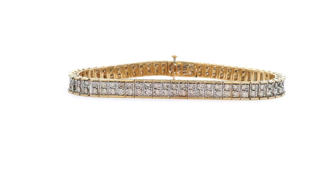 14KT Yellow Gold 5.07 ctw Double Row Diamond Tennis Bracelet: A striking 14KT yellow gold double-row diamond tennis bracelet featuring 122 round brilliant cut diamonds totaling 5.07 carats. Measuring 7 1/4 inches, this elegant bracelet is crafted with a bright p