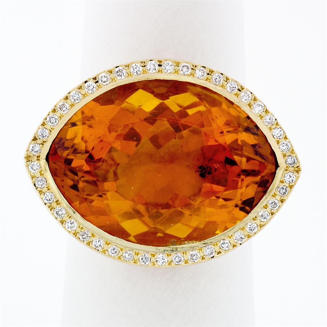 Estate 18K Gold Large Wide Citrine Diamond Halo Almond Eye Shaped Cocktail Ring: A solid 18k yellow gold almond eye shaped ring, with 1 wide fat marquise cut natural citrine (20x14.5mm), surrounded with a halo of 82 round brillaint cut natural diamonds (F/G - VS1/VS2; 0.60ctw). Th
