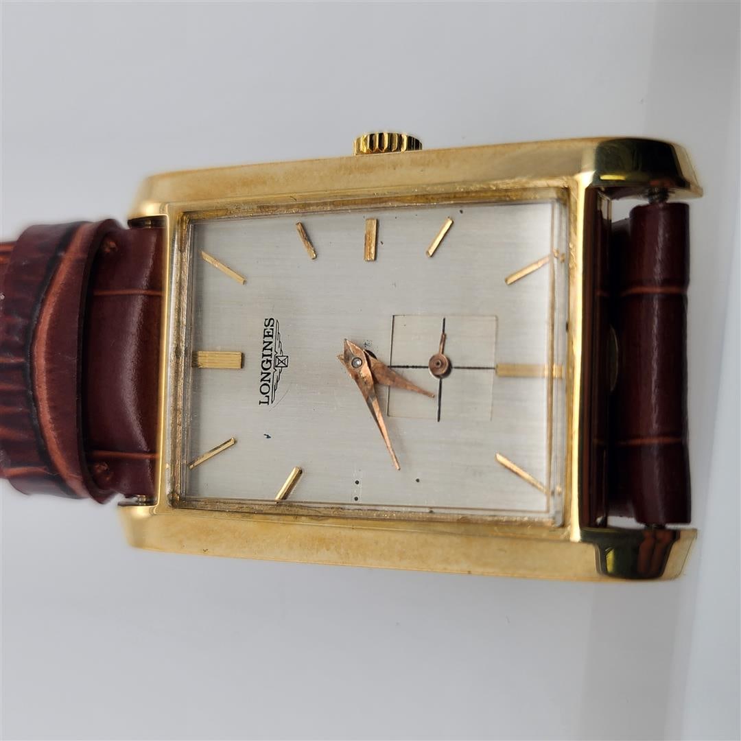 Longines Leather Wristwatch: This is a classic Longines rectangular dress watch featuring a gold case and a sleek minimalist design. The watch includes a small seconds subdial at the 6 o'clock position. Paired with a dark brown l