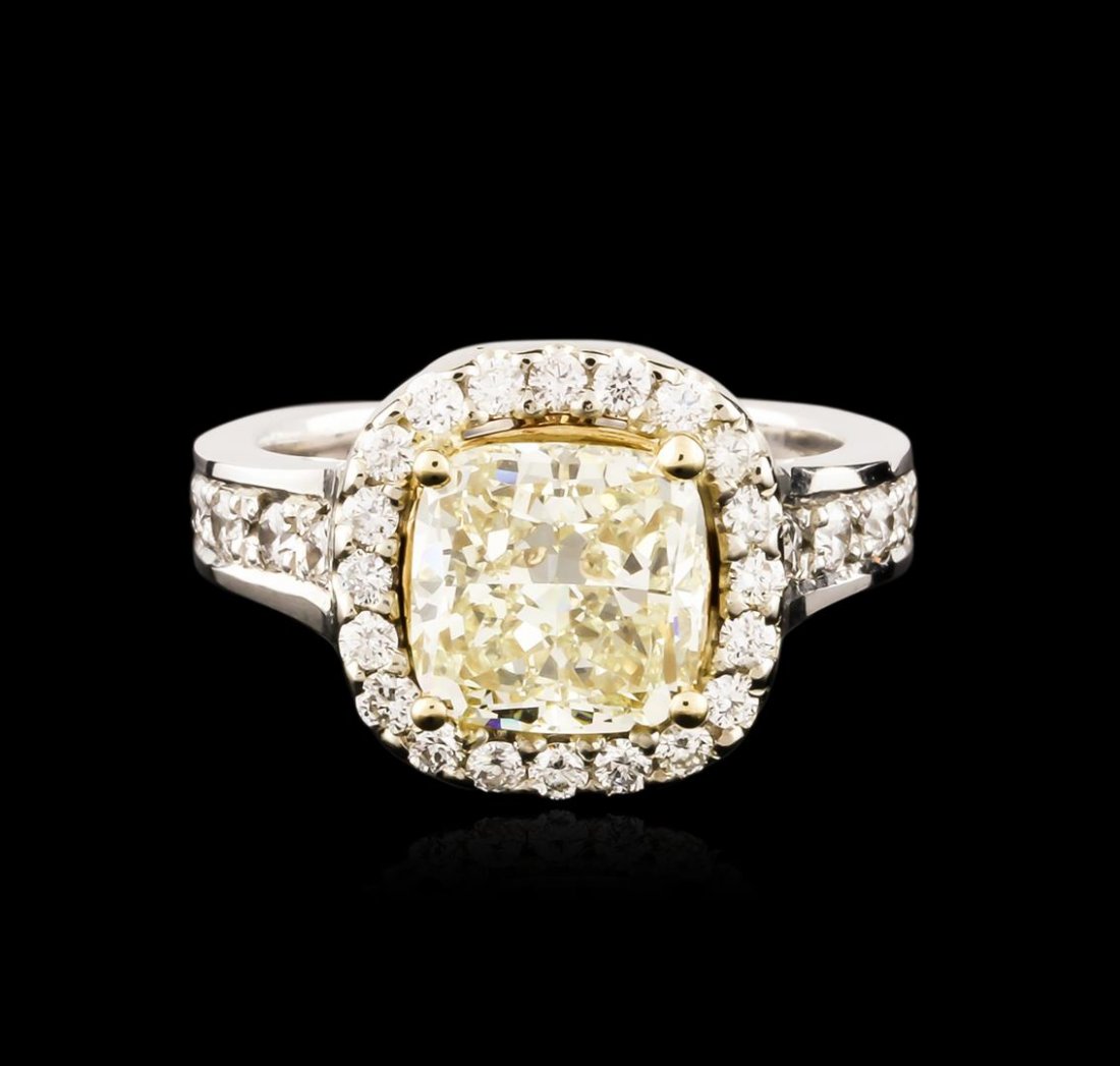 14KT White Gold 4.05ctw Fancy Yellow Diamond Ring: One electronically tested 14KT white gold ladies cast diamond ring. The featured diamond is set within an inner 18KT yellow gold basket and an outer diamond bezel supported by diamond set shoulders, c