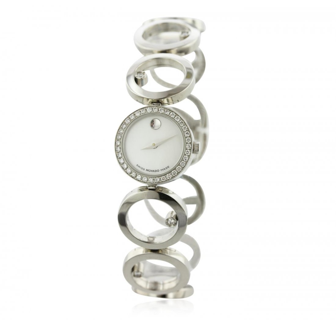 Ladies Stainless Steel Diamond Movado Wristwatch: One ladies Movado Ono Factory Medium Luxury Style Wristwatch from Movado's Belamoda Collection featuring: Diamond on Stainless Steel Fixed Bezel, White Mother of Pearl Museum Dial, Analog Display, Sta
