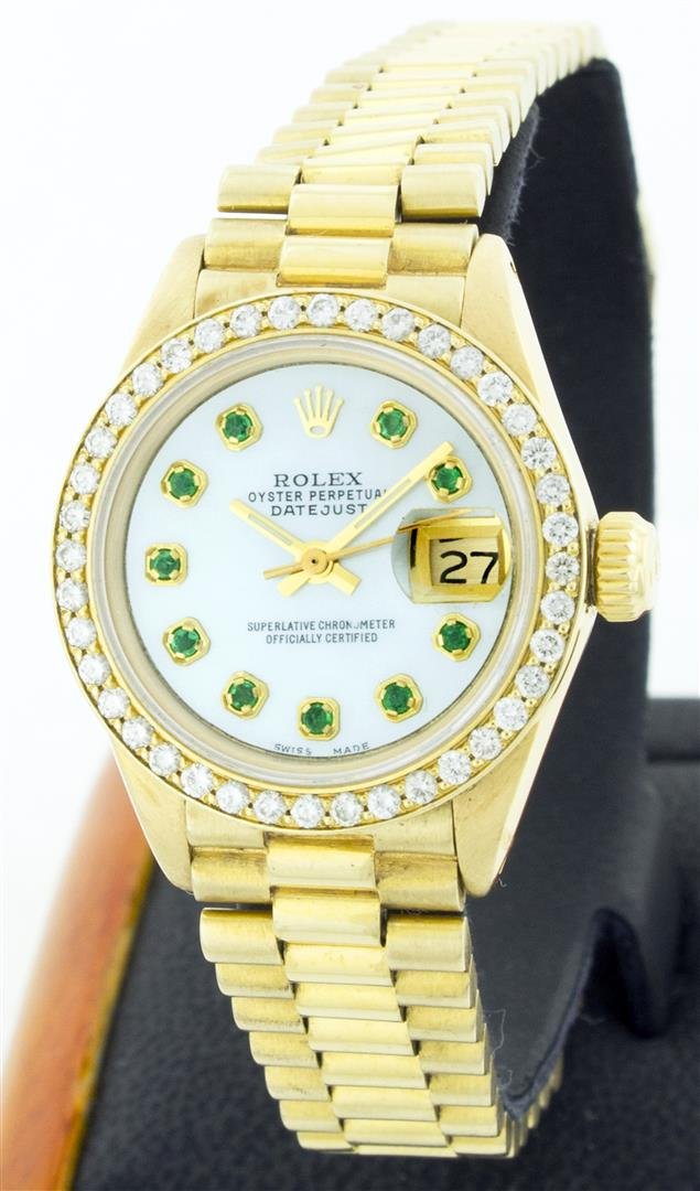 Rolex President 18KT Gold Diamond and Emerald Ladies: One Ladies Rolex President Polished, Serviced & Electronically Tested, Yellow Gold Case: 26mm, Yellow Gold Crown, Custom Bezel: 18K Yellow Gold Bead Set Diamond Bezel, Diamond Count: 32 Diamonds Total