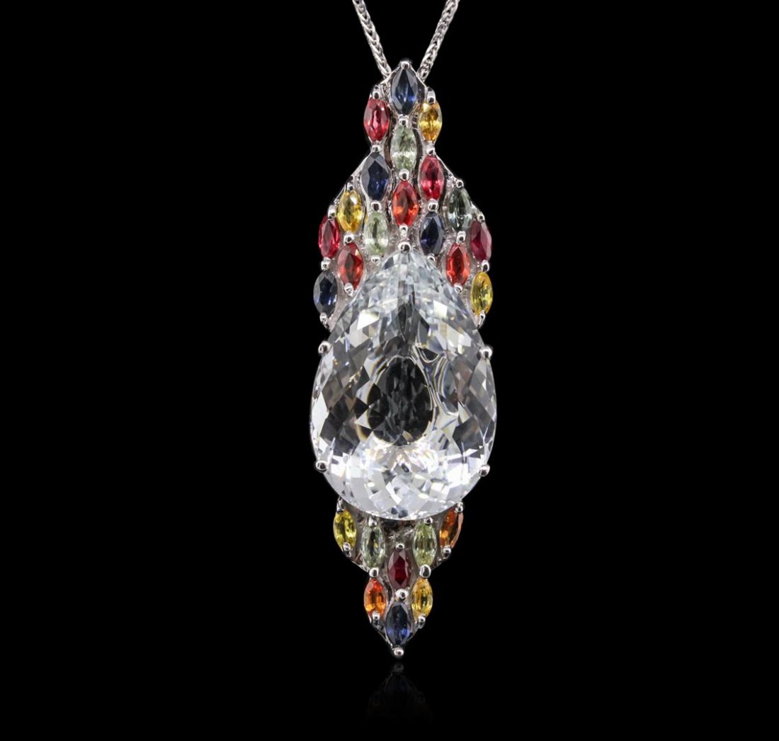14KT White Gold 23.00ct Beryl, Sapphire and Ruby: One electronically tested 14KT white gold ladies cast & assembled multi-gemstone pendant with chain. Condition is new, good workmanship. The pendant features a beryl set within a multi-gemstone bezel,