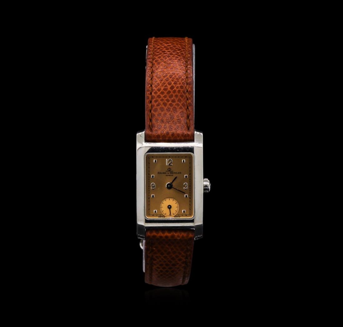 Baume & Mercier Geneve Watch: One Baume & Mercier Geneve Watch. Light bronze dial stainless steel watch with a brown leather band.