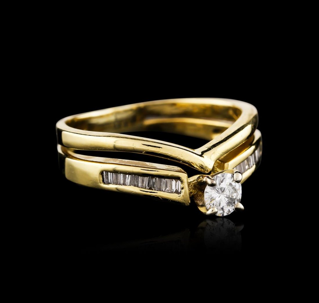 14KT Yellow Gold 0.34ctw Diamond Wedding Ring Set: One wedding ring set featuring: 14KT yellow gold weighing 5.10 grams containing one center diamonds with a total weight of 0.20ct and baguette cut diamonds with a total weight of 0.14ct.