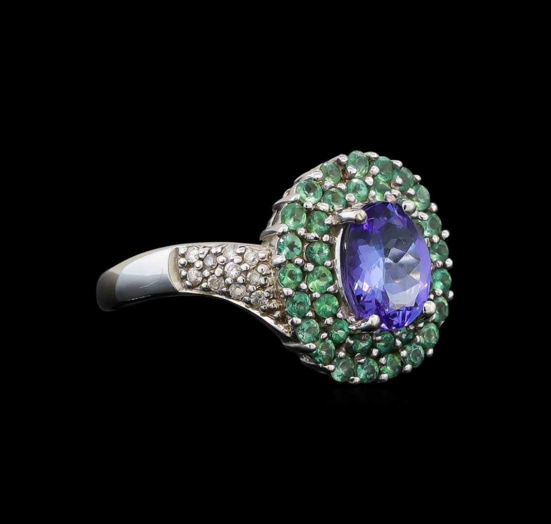 14KT White Gold 1.53 ctw Tanzanite, Emerald and Diamond: One electronically tested 14KT white gold ladies cast tanzanite, emerald and diamond ring with a bright polish finish. Identified with markings of "14K". Condition is new. Containing: One prong set ov