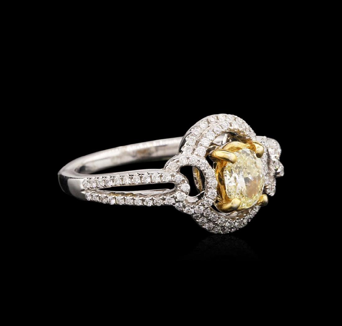18KT Two-Tone Gold 0.99 ctw Fancy Light Yellow Diamond: One electronically tested 18KT white and yellow gold ladies cast diamond engagement ring with a bright polish finish. Identified with markings of "K18". Condition is new. Containing: One prong set ova