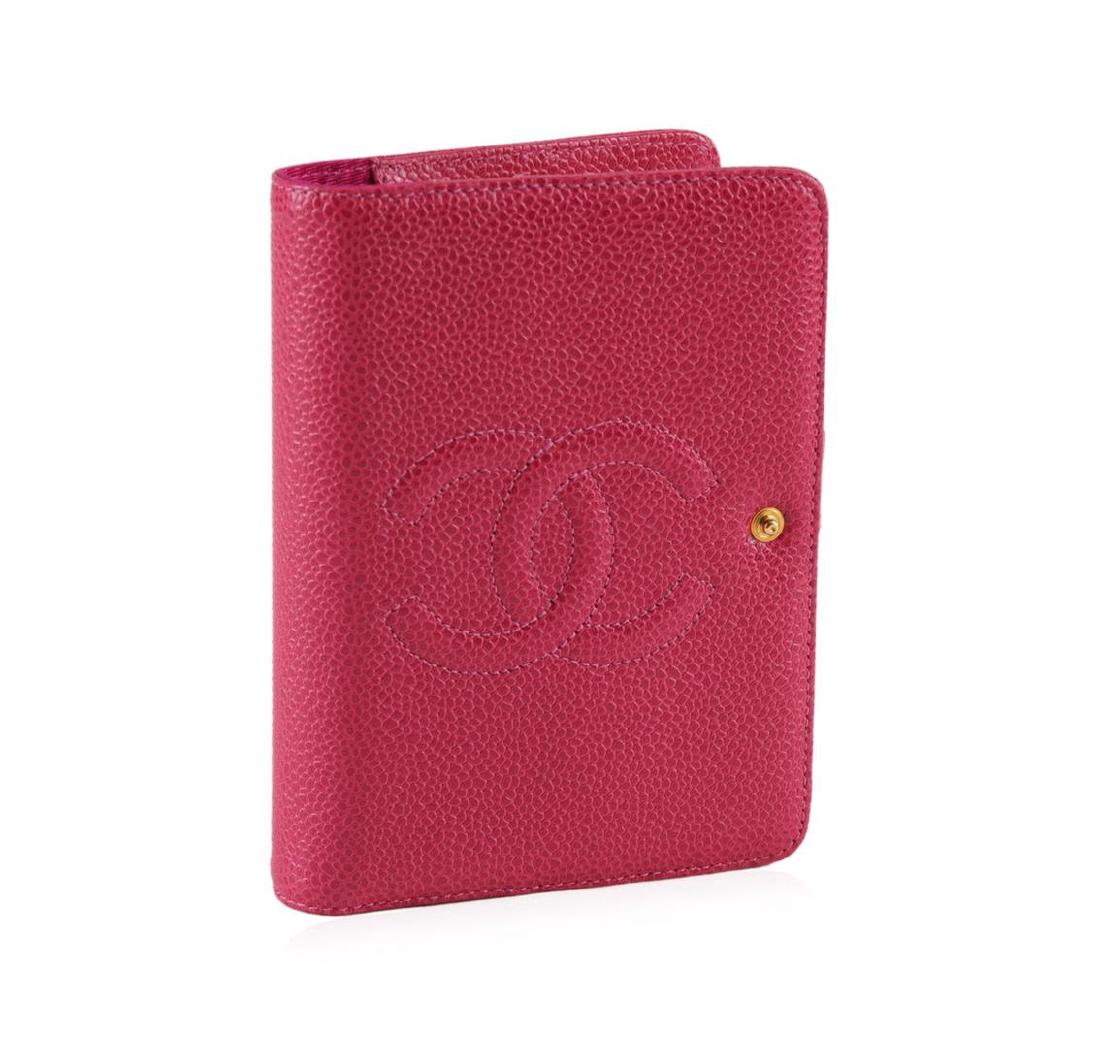 Chanel Pink Leather Notebook: One Chanel pink leather notebook, measuring 10.5 by 14 by 2 centimeters. The notebook has not been written in and is in good condition. The notebook features three slots and a pen holder for ease of u