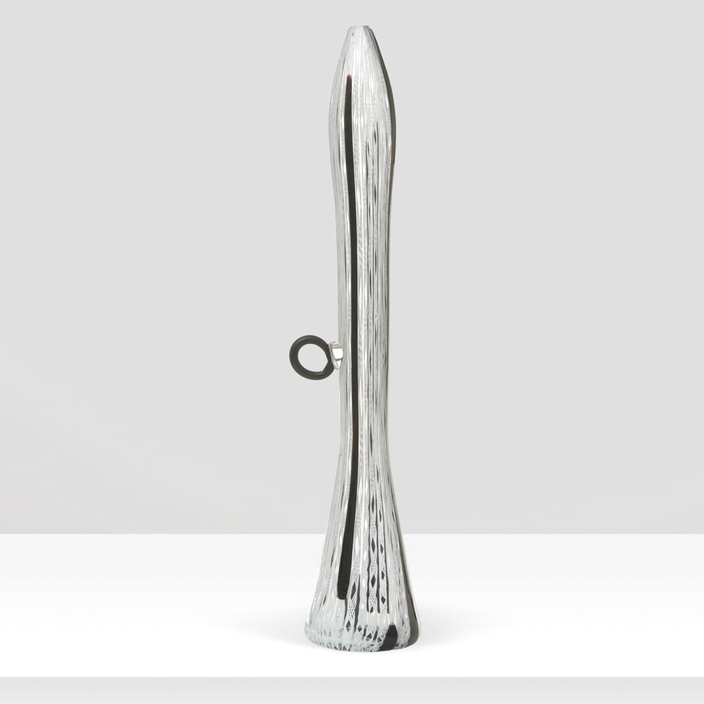 Murano Manufacture 1970s h. 51 cm.: single-stem vase with an elongated shape and a lateral ring handle, made of black canes and white zanfirico.