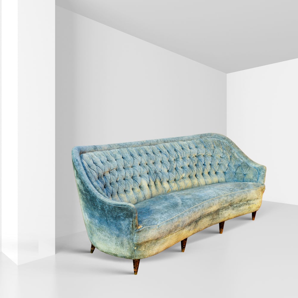Federico Munari, attributed Italy, 1980s 76x183x65 cm: three-seater sofa with shaped backrest, upholstered in blue capitonn? velvet, wooden feet, defects.