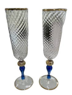 Murano Glass Champagne Flutes: Beautiful pair of champagne flutes made by one of Murano's top Artisans, Fratelli Tessaro. Beautiful blue coloring and gold trim. Measure 8.5" tall.