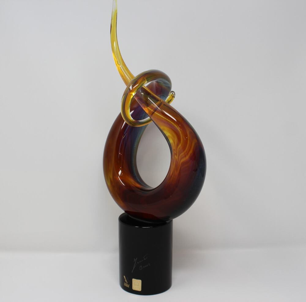 Curl Ribbon Sculpture From Murano: A beautiful Murano Glass sculpture by Famed Glass Master Oscar Zanetti. Made using the calcedonia glass method which creates beautiful reflections in a multitude of colors. Signed by the Artist. Measu