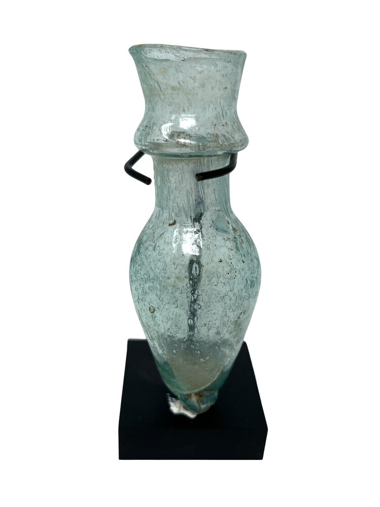 Ancient Unguentarium from Persia: This unguentarium is approximately 1,000 years old and is from the Persian area. Includes small display stand. In remarkable condition for its age. Measures 4" tall.