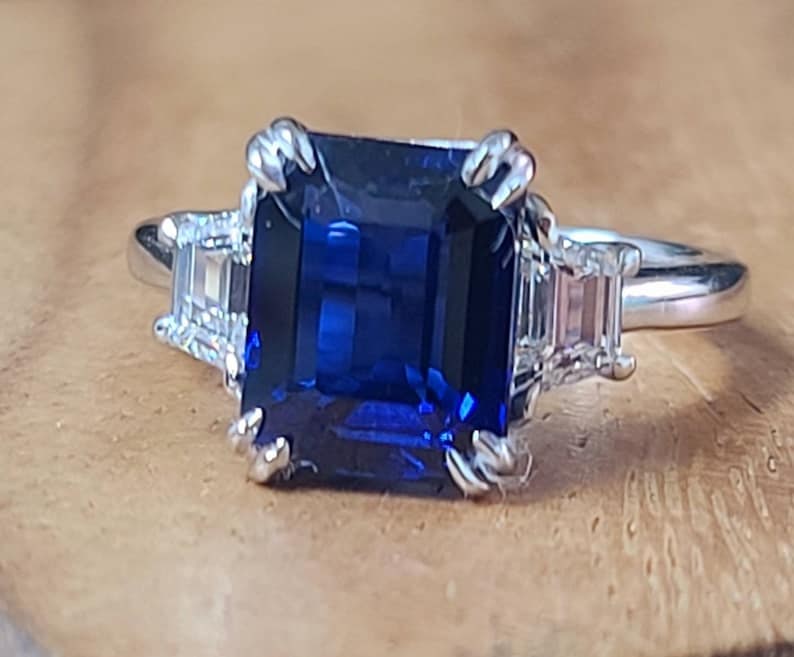 Certified 10 Carat Emerald cut Lab Grown Blue Sapphire Engagement Ring 14KT Solid White Gold: Certified 10 Carat Emerald cut Lab Grown Blue Sapphire Engagement Ring 14KT Solid White Gold - Ring Size US -6 Side stone 0.60 Ct Lab Grown Diamonds Fancy VS1 E Color