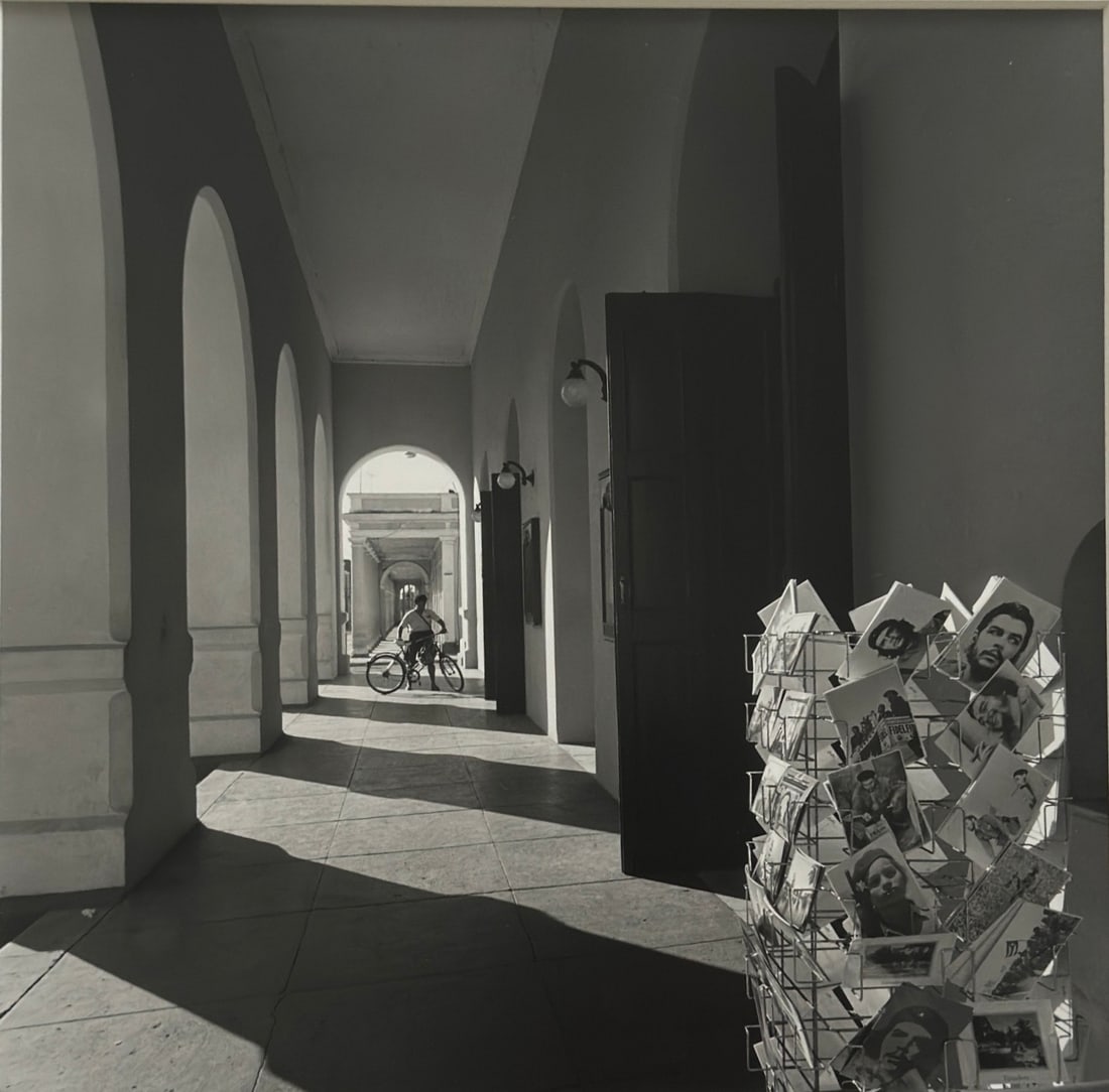 Mario Algaze, b. Cuba, "Iconografia Socialista", 1999-2000: Silver Gelatin photograph, 10 x 10 inches. This photograph by Cuban Artist Mario Algaze is both documentary and conceptual. It captures a precise urban moment—light, architecture, a man with a