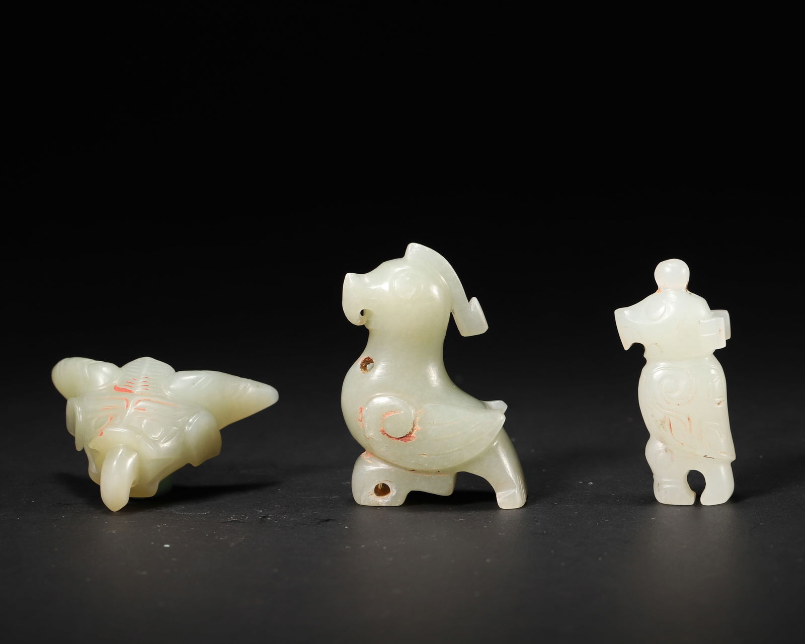 Shang Dynasty Jade Beast Assemblage (Bird, Ox-Head, Human Form): W: 3cm (1.18in), H: 4.5cm (1.77in)A 3-piece Shang jade set: bird-shaped, ox-head, and human-form ornaments. With lustrous jade, spiral patterns, and residual cinnabar, its concise archaic style reflec